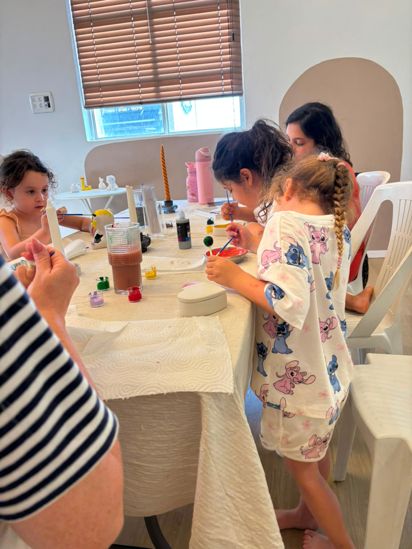 ילדות צובעות פסלוני חרס בסדנת יצירה