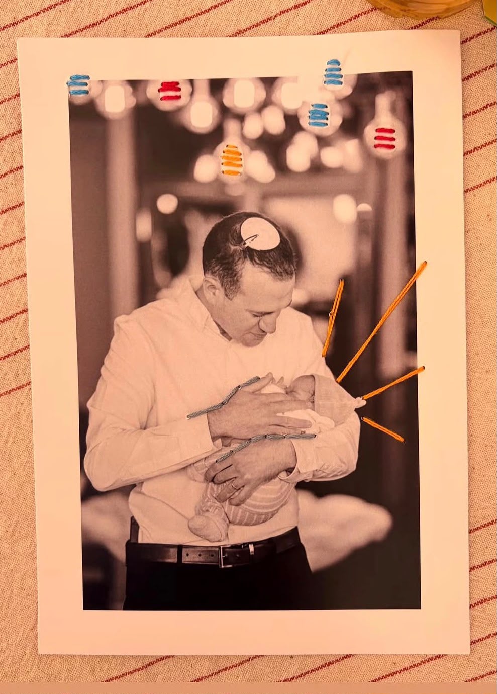 צילום אב ותינוק עם רקמה בצבעי כתום וכחול