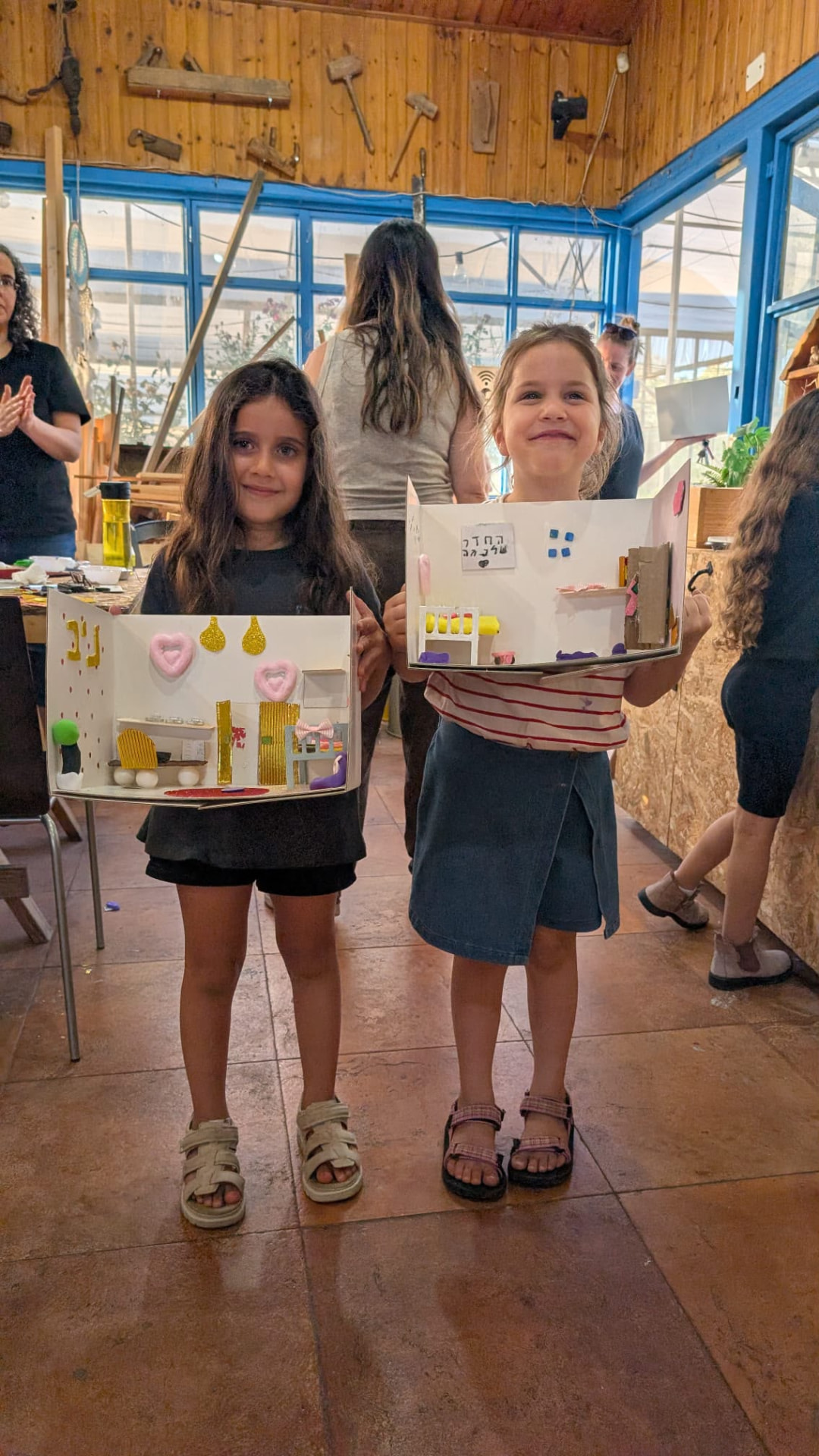 שתי ילדות מציגות בגאווה את חדרי החלומות שיצרו